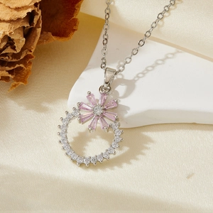 Vue détaillée du pendentif fleur argenté orné de cristaux roses et blancs sur tissu