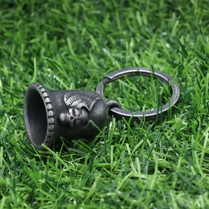 Guardian bell motorcycle keychain with skull and wings motif on green grass background