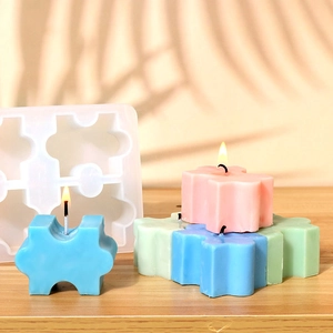 Dettaglio dello stampo in silicone a puzzle e candele artigianali in colori pastello