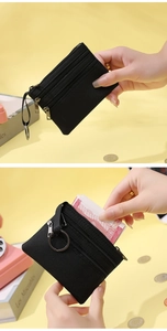 Détail du porte-monnaie noir en tissu avec trois compartiments zippés et porte-clés