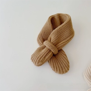 Detail of tan ribbed knit baby scarf with cross-through loop design on white background