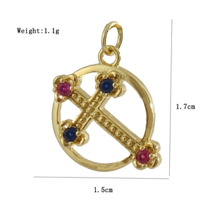 Detailed view of a gold-plated Virgin Mary cross pendant with red and blue gemstones