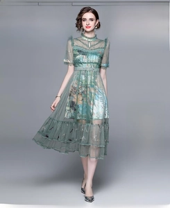Detail of dark green mesh maxi dress featuring floral embroidery and elegant lace texture