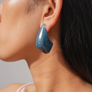 Close-up of marble textured resin earrings with blue and grey fluid patterns and glitter