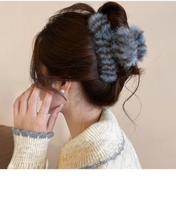 Close-up of blue-grey plush striped hair claw clip on model's head for winter style