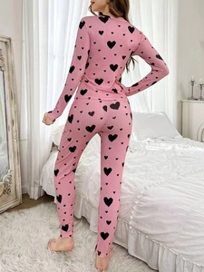 Detail of pink ribbed loungewear set with black heart print and slim fit long pants