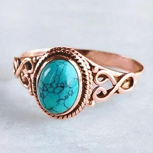 Macro view of rose gold turquoise ring featuring hollowed vine patterns and rope edging