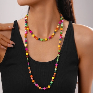 Detail view of colorful bohemian faux crystal and shell beaded necklace on a model