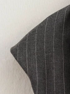Gros plan détaillé du tissu gris foncé à rayures blanches avec un drapé élégant et fluide