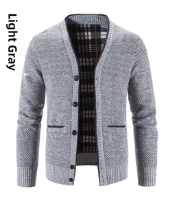 Details einer hellgrauen Strickjacke mit Knopfverschluss und schwarz-weißem Karofutter