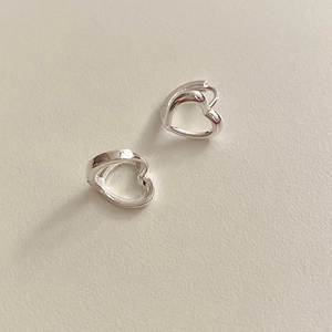 Gros plan de boucles d'oreilles cœur en argent sterling S925 poli sur fond blanc minimaliste