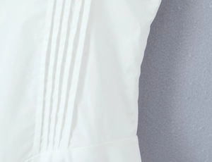 Detail shot of white dress fabric with professional vertical pleats and textured weave