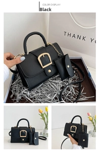 Detail of black crossbody bag with matte lychee texture and golden horseshoe buckle
