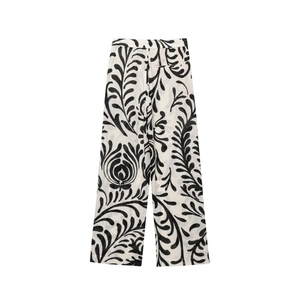 Flat lay of wide-leg trousers with elegant black and white floral vine print texture