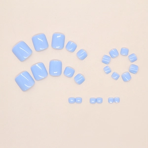 Flat lay view of 24 pieces light blue glossy press-on toenails on a cream background