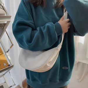 Minimalist beige crescent crossbody bag in soft leather with adjustable woven strap