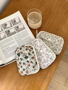 Detailed view of quilted cotton fabric card holders with floral patterns and snap button