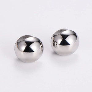 Close-up of highly polished silver stainless steel spherical earrings on white background