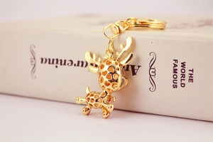 Close-up of golden metal giraffe keychain with hollow spots on a book spine
