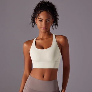 Dettaglio del reggiseno sportivo crema con schiena incrociata e leggings yoga viola alti