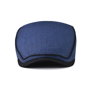Detailed close-up of dark blue cotton flat cap with black stitching and textured fabric