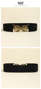 Detailed close-up of vintage bronze crane buckle on black elastic waist belt