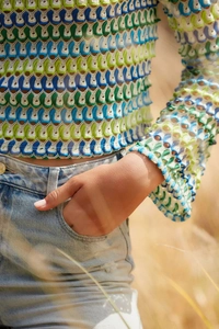 Gros plan d'un haut au crochet multicolore avec dentelle festonnée et texture ajourée