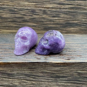 2.8cm natural amethyst hand-carved crystal skull figurines on dark wood surface