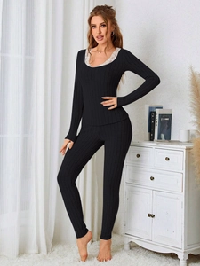 Detail of women's black ribbed loungewear set featuring elegant white lace neckline