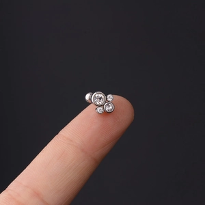 Macro shot of 16G stainless steel cartilage stud with cluster of four clear zircons