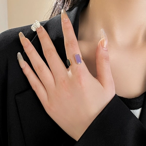 Detail of gold open ring featuring black and purple rectangular oil-dripped geometric inlays