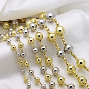 Elegant tiered gold and silver beaded necklaces on a smooth white satin background
