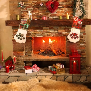 Gros plan de chaussettes de Noël en forme de patte de chien sur une cheminée festive