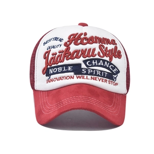 Close-up of 3D embroidery detail on red and white mesh trucker baseball cap