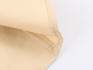 Close-up of beige woven fabric showing heavy embroidery stitches and high-quality seam details