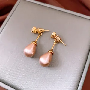 Orecchini pendenti con perle vintage oro champagne e dettaglio a sbalzo elegante