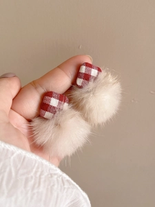 Detail of red plaid fabric square stud earrings with soft beige plush fur ball charms