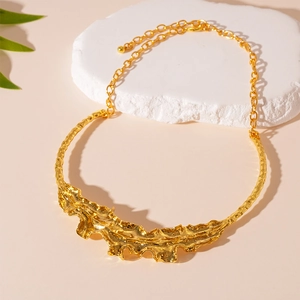 Statement gold leaf chain necklace with heavy crumpled metal texture and liquid molten style