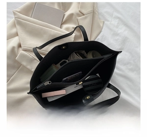 Internal view of black leather tote bag showing large capacity and zipper compartments