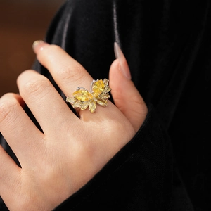 Gros plan sur la bague papillon avec pierres marquises jaunes sur velours noir