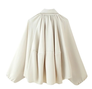 Detail view of the vertical pleats and structured back design of an off-white bomber jacket