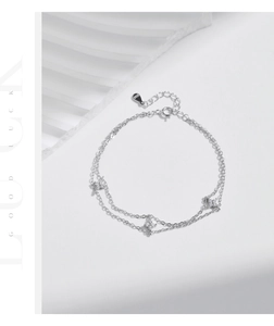 Detail of S925 sterling silver double-layer bracelet with sparkling clover charms