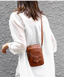 Brown PU leather crossbody bag worn by model showing vintage style and compact size