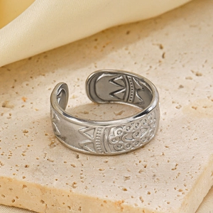 Minimalist silver stainless steel open ring with bohemian engraving on a stone surface