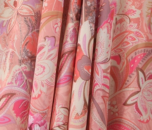 Close-up of pink paisley pattern fabric with silky texture and elegant drape