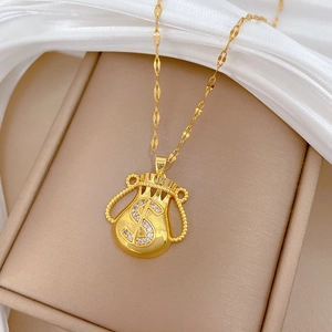 Macro shot of gold money bag pendant with dollar sign crystals on silk