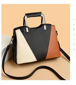 Detail of color-block tote bag with lychee texture and silver geometric metal handle