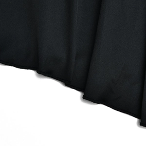 Macro detail of high-quality black fabric texture and clean hem stitching on fishtail dress