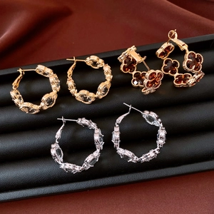 Détails de boucles d'oreilles fleurs plaquées or 18 carats et anneaux sur velours