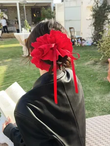Detail of red lace scrunchie with bow ribbon worn on a bun hairstyle outdoors
